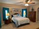 Comfortable carpeted main bedroom with ceiling fan, and ensuite bath access at 21460 Sheldon Ave, Port Charlotte, FL 33952