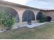 Enclosed patio with large archways provides seamless indoor-outdoor flow, complemented by lush lawn and garden views at 21460 Sheldon Ave, Port Charlotte, FL 33952