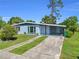 View of a single-story home with covered carport and driveway leading to a well-maintained lawn at 22219 Catherine Ave, Port Charlotte, FL 33952