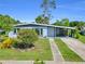 Charming single-story home featuring a covered carport and a well-maintained front yard at 22219 Catherine Ave, Port Charlotte, FL 33952