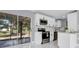 Modern kitchen with white cabinets, stainless steel appliances, and a breakfast bar overlooking the dining area at 22219 Catherine Ave, Port Charlotte, FL 33952