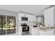 Bright kitchen with white cabinetry, stainless steel appliances and a view to the screened lanai at 22219 Catherine Ave, Port Charlotte, FL 33952