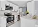 Bright kitchen with white cabinetry, stainless steel appliances and quartz countertops at 22219 Catherine Ave, Port Charlotte, FL 33952