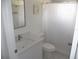 Bright bathroom features a white vanity with new fixtures, toilet, and framed art at 23167 Turnbull Ave, Port Charlotte, FL 33954