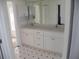 Bathroom featuring double sinks, white cabinets and modern fixtures at 23167 Turnbull Ave, Port Charlotte, FL 33954