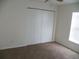Bedroom with a closet featuring bi-fold doors and neutral carpeting and a ceiling fan at 23167 Turnbull Ave, Port Charlotte, FL 33954