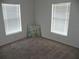 Well-lit bedroom with neutral carpet and two windows allowing ample natural light at 23167 Turnbull Ave, Port Charlotte, FL 33954