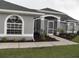 Charming single-story home featuring a well-manicured lawn, arched windows, and a screened-in entryway at 23167 Turnbull Ave, Port Charlotte, FL 33954