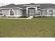 Charming single-story home featuring a well-manicured lawn, arched windows, and a screened-in entryway at 23167 Turnbull Ave, Port Charlotte, FL 33954