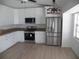 Modern kitchen featuring stainless steel appliances, white cabinets, granite countertops, and wood grain flooring at 23167 Turnbull Ave, Port Charlotte, FL 33954