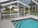 Screened-in pool with stairs and neighborhood views, creating an inviting outdoor space at 23167 Turnbull Ave, Port Charlotte, FL 33954