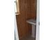 Charming powder room featuring a pedestal sink and wood-paneled walls at 23167 Turnbull Ave, Port Charlotte, FL 33954