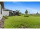 Spacious backyard with green grass and a view of the screened-in lanai at 2477 Gabel Oak Dr, North Port, FL 34289