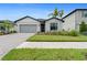 Beautiful single-story home with a well-maintained lawn, brick driveway, and modern architectural details at 2477 Gabel Oak Dr, North Port, FL 34289