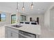 Kitchen island with a stainless steel dishwasher, pendant lighting, and a view into an adjacent living area at 2477 Gabel Oak Dr, North Port, FL 34289