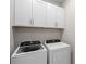 Laundry room with white washer and dryer and white cabinets above at 2477 Gabel Oak Dr, North Port, FL 34289