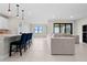 Open-concept living space with modern furnishings, tile flooring, and sliding doors to the outdoors at 2477 Gabel Oak Dr, North Port, FL 34289