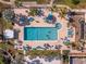 Aerial view of a sparkling community pool surrounded by palm trees, lounge chairs, and a relaxing jacuzzi at 25188 Marion Ave # 45, Punta Gorda, FL 33950