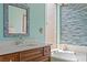 Elegant bathroom featuring a soaking tub with decorative blue mosaic tiles and a stylish vanity at 25188 Marion Ave # 45, Punta Gorda, FL 33950