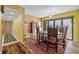 Cozy dining area with hardwood floors, a wood table with seating for four, and large glass sliding doors at 25188 Marion Ave # 45, Punta Gorda, FL 33950