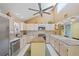 Large kitchen with stainless steel appliances, an island with seating, and tiled backsplash with unique lighting at 25188 Marion Ave # 45, Punta Gorda, FL 33950
