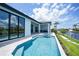 Beautiful backyard pool and outdoor kitchen area overlooking the canal with lush landscaping and tranquil waterfront views at 2815 Coral Way, Punta Gorda, FL 33950