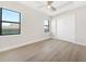 Bright bedroom features light wood floors, ceiling fan, and closet with paneled sliding doors at 2815 Coral Way, Punta Gorda, FL 33950
