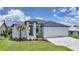 Home featuring a three-car garage, neat landscaping, and a modern entrance at 2815 Coral Way, Punta Gorda, FL 33950