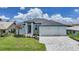 Charming home featuring a three-car garage, neat landscaping, and a welcoming entrance at 2815 Coral Way, Punta Gorda, FL 33950