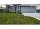 Charming light blue two-car garage home with a well-manicured lawn and beautiful landscaping at 2815 Coral Way, Punta Gorda, FL 33950