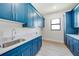 Laundry room features sleek blue cabinets, granite countertops, and stainless steel sink at 2815 Coral Way, Punta Gorda, FL 33950