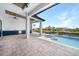 An entertainer's dream featuring a covered outdoor kitchen with blue cabinets and a beautiful pool overlooking the water at 2815 Coral Way, Punta Gorda, FL 33950