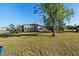 Spacious backyard with mature tree providing shade and privacy with a white door entrance at 3197 Normandy Dr, Port Charlotte, FL 33952