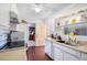 A bright kitchen with white appliances and lots of storage with white cabinets and wood style floors at 3197 Normandy Dr, Port Charlotte, FL 33952