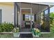 Inviting screened porch with cozy seating and potted plants creating a welcoming entrance at 3197 Normandy Dr, Port Charlotte, FL 33952