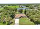 Expansive aerial view of the home, showcasing the lush trees, lawn, community park and lake at 3305 Nansen Ln, North Port, FL 34286