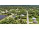 Expansive aerial view of lush neighborhood with mature trees, pond, and homes with pools at 3305 Nansen Ln, North Port, FL 34286