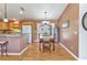 View of the dining room and kitchen with wood floors and a glass top table at 3305 Nansen Ln, North Port, FL 34286