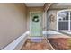 Inviting front entrance with a charming welcome mat, decorative wreath, and tiled flooring at 3305 Nansen Ln, North Port, FL 34286