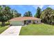 Charming single-story home with a well-maintained lawn, mature trees, and a two-car garage at 3305 Nansen Ln, North Port, FL 34286