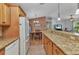 Open kitchen featuring granite countertops, wooden cabinets and stainless-steel appliances overlooking the dining room at 3305 Nansen Ln, North Port, FL 34286