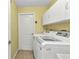 Functional laundry room with washer, dryer, storage cabinets, and easy outdoor access at 3305 Nansen Ln, North Port, FL 34286