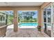 Covered lanai with decorative flooring offers a relaxing view of the pool and backyard landscaping at 3305 Nansen Ln, North Port, FL 34286
