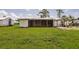 Lush backyard features a screened porch, a pergola, and green space perfect for outdoor activities at 3497 Cohoes St, Port Charlotte, FL 33952