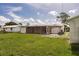 A spacious backyard includes a screened porch, green lawn, and mature trees at 3497 Cohoes St, Port Charlotte, FL 33952