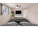 A cozy bedroom boasts a large window, ceiling fan, and a minimalist design with a sleek TV console at 3497 Cohoes St, Port Charlotte, FL 33952
