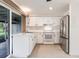 Kitchen with white cabinets, stainless steel refrigerator, and sliding door to outdoor space at 3497 Cohoes St, Port Charlotte, FL 33952