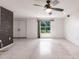 Large living room with brick accent wall and plenty of natural light from the window at 3497 Cohoes St, Port Charlotte, FL 33952