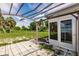 View of a patio with a pergola cover looking out on a fenced back yard at 3497 Cohoes St, Port Charlotte, FL 33952