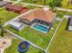 Aerial view showcasing a screened pool, firepit, and fenced-in yard with lush green lawn at 4038 Corydon Ave, North Port, FL 34286